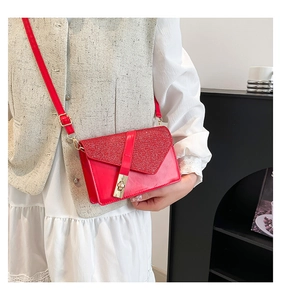 Close-up of red sequined flap bag with gold rectangular clasp and slim shoulder strap