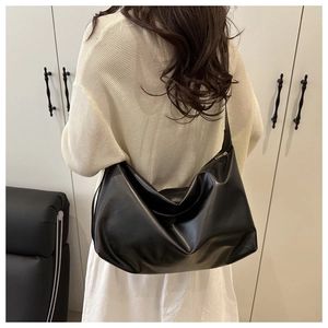 Dettaglio borsa tote grande in pelle nera con texture morbida e zip dorata