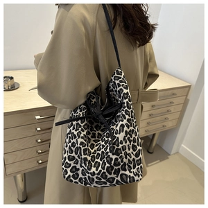 Detail of leopard print tote bag with drawstring closure and black ribbon bow accent