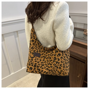 Detail of a leopard print corduroy tote bag with an embossed leather 'FASHION' patch
