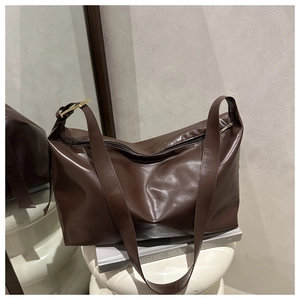 Dettaglio borsa tote marrone scuro con pelle sintetica lucida e fibbia dorata
