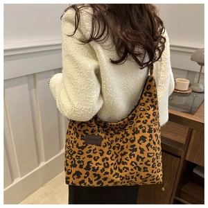 Detail of leopard print corduroy tote bag with brown fashion leather patch and soft texture