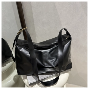 Dettaglio della borsa tote nera con fibbia quadrata dorata e tracolla regolabile in pelle PU