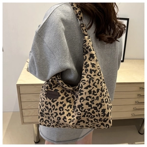 Close-up of leopard print corduroy tote bag featuring a leather FASHION label detail