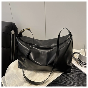 Dettaglio tracolla regolabile con fibbie dorate su una borsa tote nera elegante