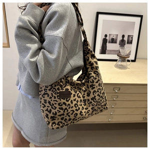 Close-up of leopard print corduroy tote bag showing fashion leather patch and texture