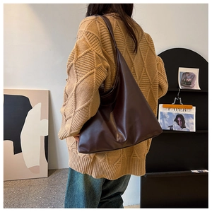 Detail of dark brown leather tote bag with thick strap and middle seam stitching