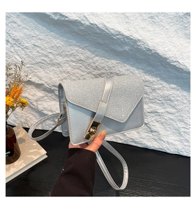 Detail of silver glitter crossbody bag with elegant gold metal buckle and smooth leather