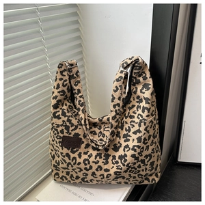 Detail of leopard print corduroy tote bag showing soft ribbed texture and leather logo patch