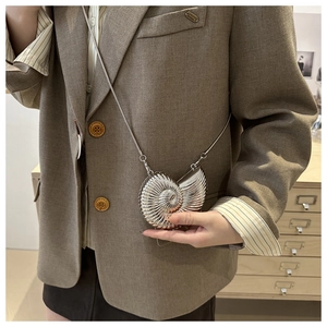 Detailed view of silver nautilus-shaped crossbody bag with metallic spiral texture