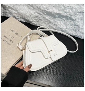 Detail of white litchi pattern leather handbag with asymmetric wave flap and gold U-buckle