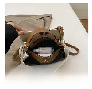Interior view of bicolor bucket bag showing central zipper pocket and magnetic buckle