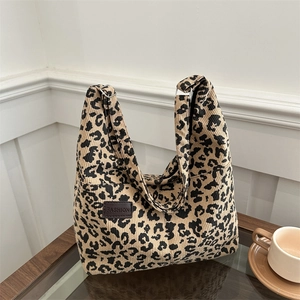 Leopard print corduroy tote bag for women with fashion leather label on a coffee table