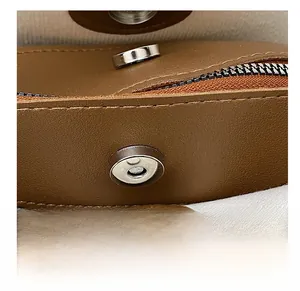 Close-up of the silver magnetic buckle and textured brown leather on this stylish tote