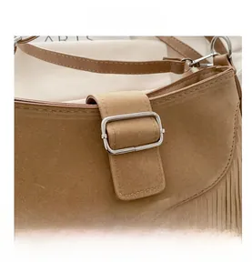 Détail de la besace en daim marron avec de longues franges et une boucle métallique chic