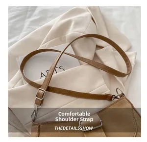 Détail de la bandoulière réglable sur le sac besace en daim marron avec boucle argent