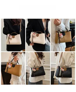 Detail view of stylish color-block tote bag in multiple colors with bear charm