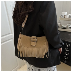 Gros plan d'un sac à bandoulière en daim marron avec de longues franges et boucle métal