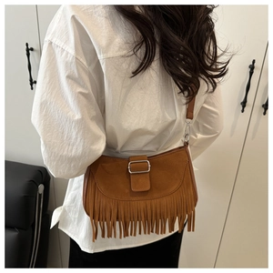 Détails des longues franges et de la texture en daim mat du sac à bandoulière marron