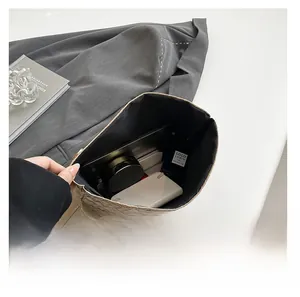 Top view of woven leather bag interior showing space for phone, perfume and makeup
