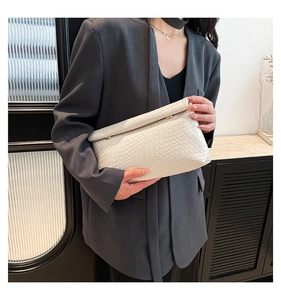 Vue détaillée du sac bandoulière blanc tissé montrant le cuir synthétique texturé et le fermoir