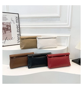 Detail view of stylish woven clutch bags in khaki, white, brown, black and red colors