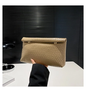 Detail of khaki woven envelope clutch bag with golden circular metal buckles
