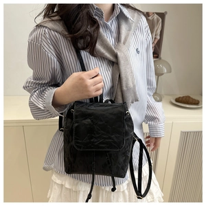 Détail d'un mini sac à dos noir avec texture froissée et fermeture à cordon pratique