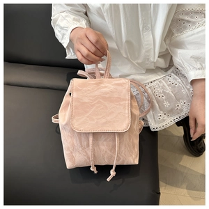 Détail du mini sac à dos rose pâle en similicuir froissé avec fermeture à cordon