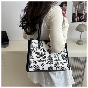 Borsa tote con stampa a inchiostro cinese e bordi in pelle mostrata indossata da modella