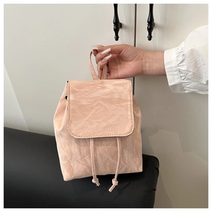 Detail of light pink mini backpack featuring unique paper-texture wrinkled fabric and drawstring