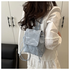 Détail d'un sac à dos bleu clair à texture marbre avec rabat et cordon de serrage