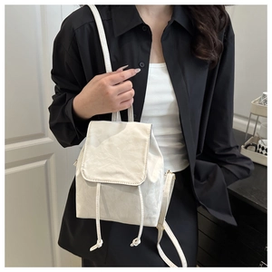 Détail du mini sac à dos blanc avec cordon et texture en similicuir plissé