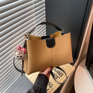 Litchi pattern brown tote bag with black handles and a cute plush charm accessory