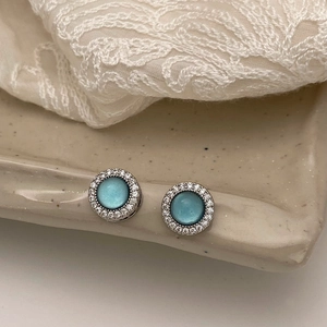 Elegant silver earrings with blue gemstone and white cubic zirconia halo on lace