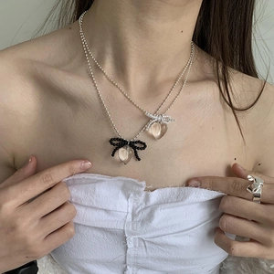 Double-layered transparent heart pendant necklace with bow charms on silver ball chain