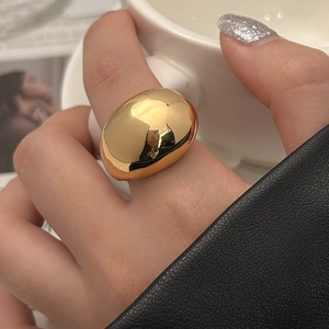 Close-up of minimalist chunky 18K gold ring with high-polished mirror finish for women
