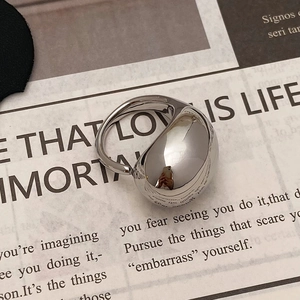 Close-up of polished silver liquid metal ring on newspaper background