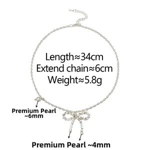 Detail of silver bow pendant necklace with three white pearls on a clean white background