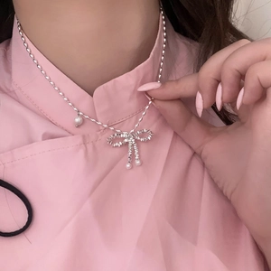 Elegant silver bow pendant necklace with pearls on a twisted rope chain for women