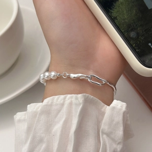 Elegant pearl and textured silver chain bracelet shown on wrist with a minimalist aesthetic