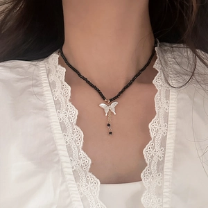 Collier en perles de spinelle noire avec pendentif papillon blanc et pompons métalliques