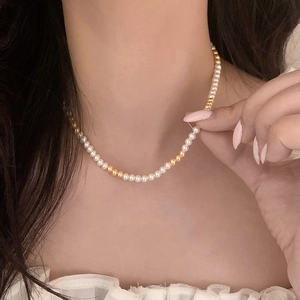 Élégant collier de perles et billes dorées style vintage français porté par un modèle