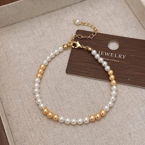 Détail du collier de perles et billes dorées avec fermoir mousqueton réglable exposé