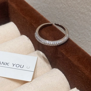 Detail view of silver adjustable open ring with rows of micro-paved white zircons on velvet