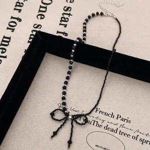 Detail of black beaded bow choker necklace with faceted crystals on vintage background