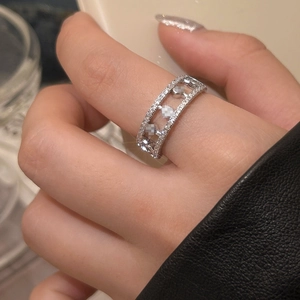 Macro detail of silver move ring with three sliding cubic zirconia stones on model finger