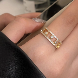 Detailed view of a gold rectangular ring with sparkling zircons and five movable beads