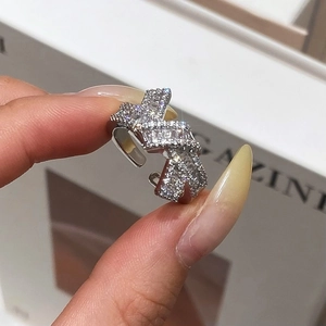 Close-up of a silver bow knot zircon ring with adjustable open band and pavé crystals