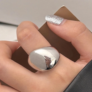Detailed close-up of a high-polished teardrop ring with a minimalist curved design